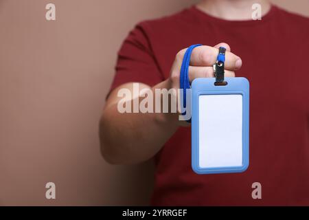 Uomo con distintivo vuoto su sfondo marrone, primo piano. Spazio per il testo Foto Stock