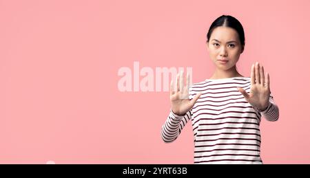 Ritratto di giovane donna asiatica seria che mostra Stop Gesture a Camera Foto Stock