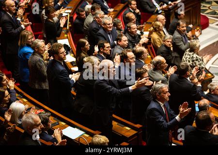 Parigi, Francia, 04/12/2024, deputati dell'Ensemble pour la République gridano ai deputati di sinistra durante la discussione della mozione di censura all'Assemblea nazionale. L'Assemblea nazionale francese ha adottato una mozione di censura contro il primo ministro Michel Barnier, che lo ha deposto dopo soli tre mesi di mandato. La mozione fu sostenuta dalla coalizione di sinistra Nouveau Front Populaire e dal partito di estrema destra Rassemblement National, ottenendo 331 voti a favore. Questo segna un significativo cambiamento politico, in quanto l'assemblea spoglia il capo del governo. Foto Stock