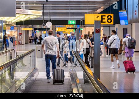 Passeggeri sul passaggio pedonale mobile nell'edificio del terminal dell'aeroporto internazionale Schipol, Amsterdam, Olanda Foto Stock