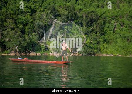 Un pescatore che lancia una rete sul lago Ba Be nel Parco Nazionale Ba Be nella provincia di Bac Kan, Vietnam Foto Stock