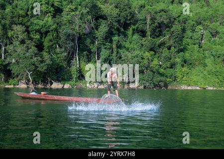 Un pescatore che lancia una rete sul lago Ba Be nel Parco Nazionale Ba Be nella provincia di Bac Kan, Vietnam Foto Stock