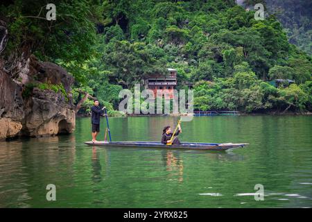 Un uomo e una donna Tay etnici in una barca sul lago Ba Be nel Parco Nazionale di Ba Be nella provincia di Bac Kan, Vietnam Foto Stock