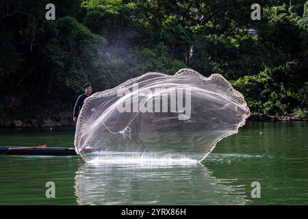 Un pescatore Tay che lancia una rete sul lago Ba Be nel Parco Nazionale di Ba Be nella provincia di Bac Kan, Vietnam Foto Stock