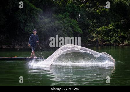 Un pescatore Tay che lancia una rete sul lago Ba Be nel Parco Nazionale di Ba Be nella provincia di Bac Kan, Vietnam Foto Stock