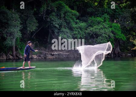 Un pescatore Tay che lancia una rete sul lago Ba Be nel Parco Nazionale di Ba Be nella provincia di Bac Kan, Vietnam Foto Stock