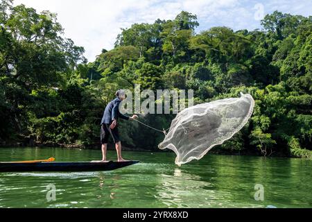 Un pescatore Tay che lancia una rete sul lago Ba Be nel Parco Nazionale di Ba Be nella provincia di Bac Kan, Vietnam Foto Stock