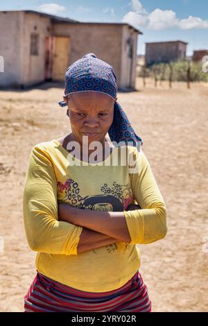 donna africana del villaggio in piedi nel cortile con le braccia incrociate Foto Stock