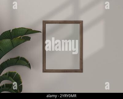 mockup con cornice in legno su parete bianca con luce naturale, arredamento minimalista con poster vuoto. Foto Stock