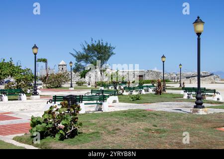 Un piacevole parco con panche in legno e la fortezza del Castillo de San Salvador de la Punta XVI secolo nel centro di la Habana, l'Avana, Cuba Foto Stock