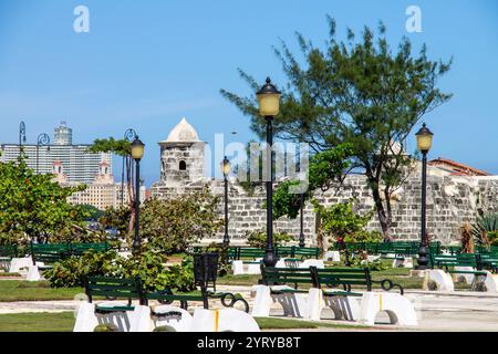 Un piacevole parco con panche in legno e la fortezza del Castillo de San Salvador de la Punta XVI secolo nel centro di la Habana, l'Avana, Cuba Foto Stock