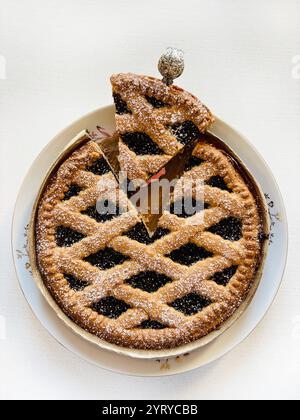 Crostata fatta in casa con marmellata di frutti di bosco isolata su sfondo bianco. Crostata Linzer, dessert austriaco. Direttamente sopra. Foto Stock