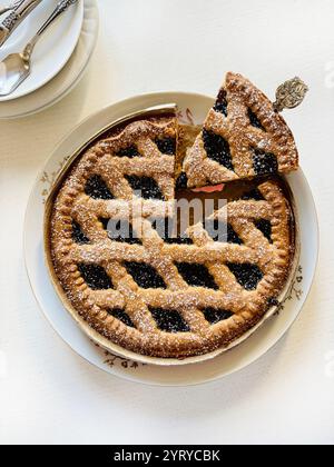 Crostata fatta in casa con marmellata di frutti di bosco isolata su sfondo bianco. Crostata Linzer, dessert austriaco. Direttamente sopra. Foto Stock