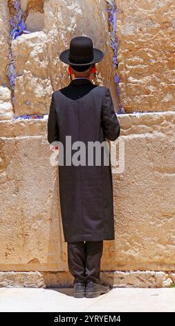 L'ebreo assidico prega presso il muro Occidentale, (muro del pianto, o Kotel), un antico muro di pietra calcarea nella città vecchia di Gerusalemme. Si tratta di un segmento relativamente piccolo di un antico muro di contenimento molto più lungo. Il muro fu originariamente eretto come parte dell'espansione del secondo Tempio ebraico iniziata da Erode il grande, Foto Stock