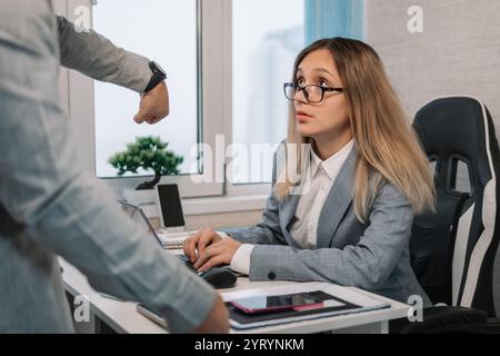 Tempo di lavoro scaduto. i concetti sono in ritardo per il lavoro. Donna sconvolta che viene rimproverata dal capo per essere arrivata tardi in ufficio, manager frustrato che si sente in colpa Foto Stock