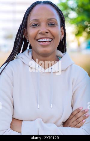Ritratto di una giovane donna sorridente con trecce all'aperto in un ambiente naturale Foto Stock
