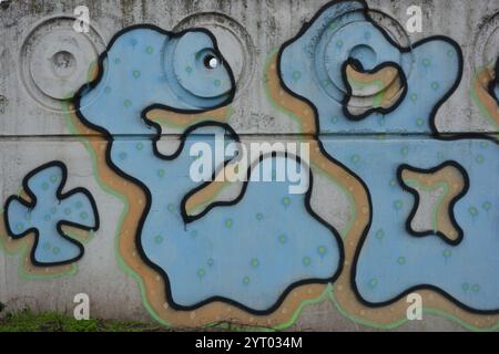 Lettere blu con punti blu scuro e linee nere con bordi gialli. Un disegno, graffiti raffiguranti la parola * EBOY * su una recinzione in cemento. Foto Stock