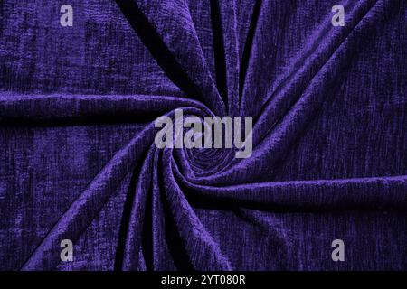 Un bel campione di tessuto di velluto di blu scuro ritorto in una spirale. pieghe morbide ed eleganti. Esempio di trama del tessuto. l'ombra del colore dell'anno Foto Stock