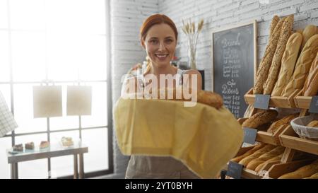 Donna che mostra pane fresco in un intimo interno di panetteria con un arredamento elegante, con diversi pasticcini esposti sugli scaffali. Foto Stock