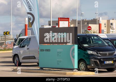 La concessionaria di auto Spoticar firma con i veicoli parcheggiati, sottolineando le vendite di auto usate e l'industria automobilistica in portogallo Foto Stock