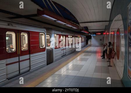 La metropolitana di Sofia, Bulgaria, presso la stazione di Joliot-Curie presenta una moderna architettura piastrellata, treni della metropolitana rossi e pendolari che aspettano su una piattaforma pulita. Foto Stock
