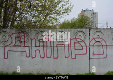 Lettere grigie trasparenti e sottili linee rosse. I graffiti raffiguranti la parola sono dipinti su una recinzione di cemento bianca e grigia. Foto Stock
