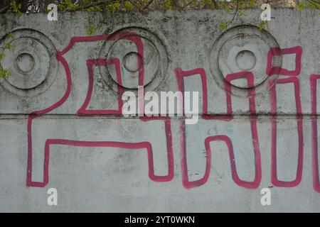 Lettere grigie trasparenti e sottili linee rosse. I graffiti raffiguranti la parola sono dipinti su una recinzione di cemento bianca e grigia. Foto Stock