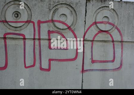 Lettere grigie trasparenti e sottili linee rosse. I graffiti raffiguranti la parola sono dipinti su una recinzione di cemento bianca e grigia. Foto Stock