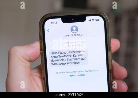 Hand hält ein Mobiltelefon mit einer WhatsApp -Nachricht, Die der Beginn eines Messengerbetrugsfall ist *** Hand tiene un telefono cellulare con un messaggio WhatsApp, che è l'inizio di un caso di truffa messaggera Nordrhein-Westfalen Deutschland, Germania GMS18122 Foto Stock