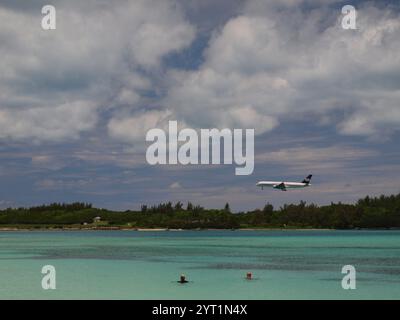 Jet Airliner atterra all'aeroporto internazionale L.F. Wade alle Bermuda. Gli amanti della spiaggia di Clearwater si godranno le calde acque mentre atterrano gli aerei. Foto Stock