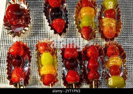 Delizioso piatto di vivaci spiedini di frutta, un assortimento di frutta smaltata disposta ad arte Foto Stock