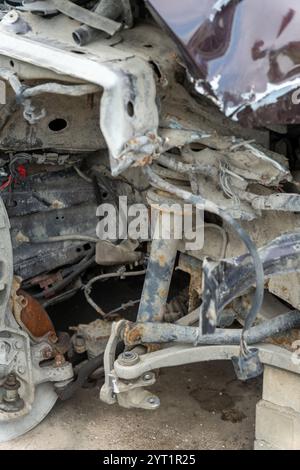 Un'autovettura è parcheggiata nel parcheggio con danni alla parte anteriore destra a seguito di un incidente. Sospensione, parafango, cofano e radiatore Foto Stock