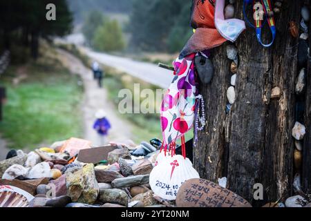 tumulo di pietre votive e offerte, Cruz de ferro (Croce di ferro), collina di Foncebadón, regione di Bierzo, Castiglia e León, Spagna Foto Stock