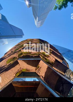 New York, USA - 2 giugno 1024: Ciclista in Bronx Street Scene con binari ferroviari sopraelevati e punti vendita locali Foto Stock