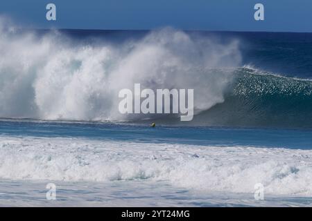 Oahu, Hawaii. 30 novembre 2024. L'ambasciatrice del surf della Patagonia Eala Stewart emerge dal tubo in una nuvola di spruzzi presso il gasdotto di Banzai. Foto Stock