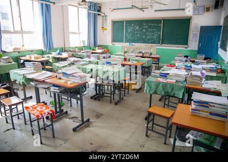 Aula con scrivania e libri di studio presso la scuola media di Zhaozhou, Cina Foto Stock