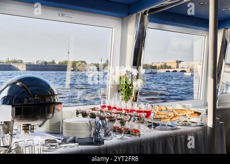 Un elegante buffet allestito su una splendida barca con una vista panoramica da godere e assaporare Foto Stock