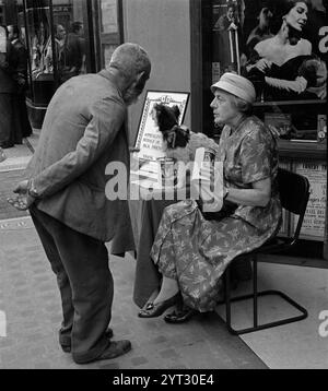Un vagabondo chiede una donazione al collezionista della PDSA, nel centro di Londra, intorno al 1950 Foto Stock