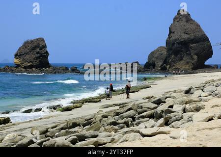 Una famiglia trascorre le vacanze scattando foto a Papuma Beach, fotografando le varie forme di roccia. Foto Stock