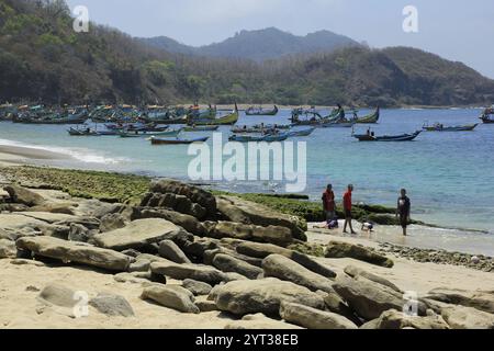 I turisti locali visitano la spiaggia di Papuma con un'imbarcazione da pesca. Papuma è famosa per le sue rocce uniche lungo le sue spiagge. Foto Stock