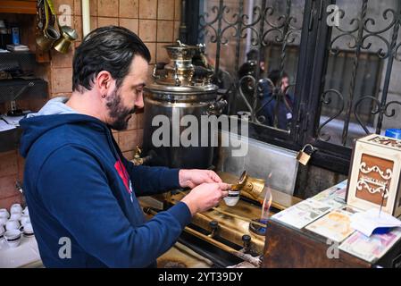 Istanbul, Turchia. 5 dicembre 2024. Un lavoratore versa caffè turco preparato in una tazza in un caffè a Istanbul, Turchia, 5 dicembre 2024. Celebrato ogni anno il 5 dicembre, il giorno commemora il riconoscimento della cultura e della tradizione del caffè turco come parte del patrimonio culturale immateriale dell'UNESCO dal 2013. Crediti: Liu lei/Xinhua/Alamy Live News Foto Stock