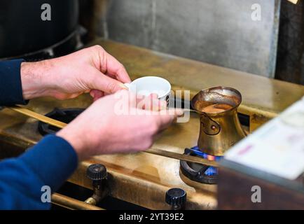 Istanbul, Turchia. 5 dicembre 2024. Un lavoratore prepara caffè turco in un caffè a Istanbul, Turchia, 5 dicembre 2024. Celebrato ogni anno il 5 dicembre, il giorno commemora il riconoscimento della cultura e della tradizione del caffè turco come parte del patrimonio culturale immateriale dell'UNESCO dal 2013. Crediti: Liu lei/Xinhua/Alamy Live News Foto Stock