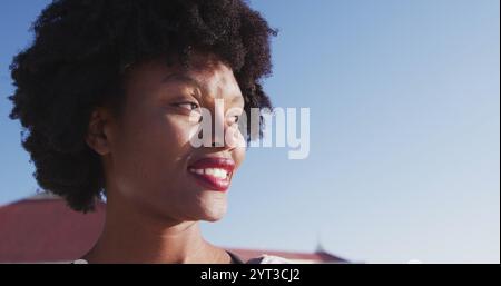 Ritratto di una donna afroamericana attraente che si diverte ad allenarsi in spiaggia in una giornata di sole, pratto Foto Stock