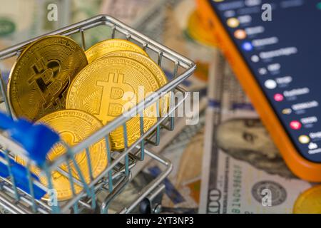 Monete bitcoin d'oro su 100 dollari nel carrello della spesa. Concetto di criptovaluta Bitcoin Foto Stock