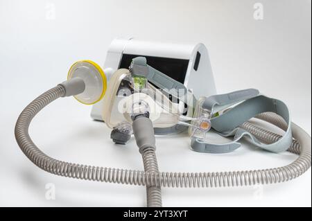 Il sistema di pressione positiva continua delle vie aeree include macchina CPAP, maschera, tubo su sfondo bianco. Foto Stock