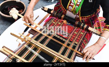 (241206) -- PECHINO, 6 dicembre 2024 (Xinhua) -- Un'artigiana dimostra tecniche di tessitura li broccato durante una mostra sulle tecniche tessili tenutasi ad Haikou, nella provincia di Hainan, nella Cina meridionale, il 30 aprile 2023. Tre elementi culturali cinesi, vale a dire le tecniche tessili tradizionali li: Filatura, tintura, tessitura e ricamo, il festival del Capodanno di Qiang, celebrato nella provincia cinese del Sichuan, e il design e le pratiche tradizionali per la costruzione di ponti ad arco in legno cinesi, sono stati aggiunti dall'UNESCO alla sua Lista rappresentativa del Patrimonio culturale immateriale dell'Umanità durante la 19a sessione dell'Inte Foto Stock