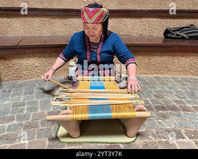 (241206) -- PECHINO, 6 dicembre 2024 (Xinhua) -- Liu Xianglan, un erede a livello nazionale delle tecniche tessili tradizionali li, dimostra tecniche di tessitura li broccato nel villaggio di Maona, città di Wuzhishan, provincia cinese meridionale di Hainan, 22 maggio 2024. Tre elementi culturali cinesi, vale a dire le tecniche tessili tradizionali li: Filatura, tintura, tessitura e ricamo, il festival del Capodanno di Qiang, celebrato nella provincia cinese del Sichuan, e il design e le pratiche tradizionali per la costruzione di ponti ad arco in legno cinesi, sono stati aggiunti dall'UNESCO alla sua Lista rappresentativa del patrimonio culturale immateriale degli Humani Foto Stock