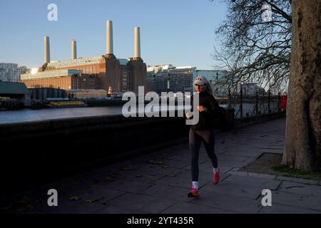 Un jogger lungo il Chelsea Embankment, Londra. La tempesta Darragh si sta avvicinando al Regno Unito e all'Irlanda e si prevede che porterà venti fino a 80 km/h e forti piogge il venerdì pomeriggio e nel fine settimana. Data foto: Venerdì 6 dicembre 2024. Foto Stock