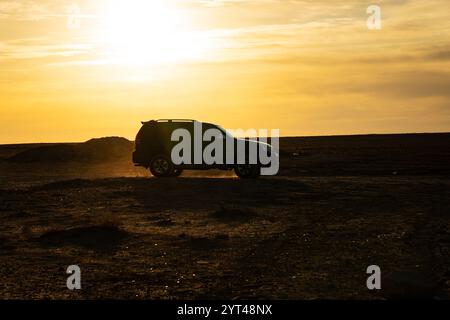 Safari nel Deserto con fuoristrada 4x4 car nella luce solare. colorato tramonto nel deserto. off-road corse in auto sulla sabbia nelle dune del deserto ai raggi del risi Foto Stock