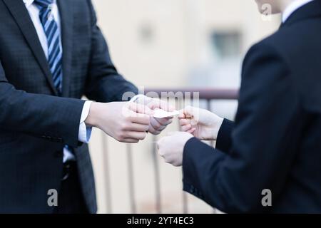 Uomo e donna che scambiano biglietti da visita in mano Foto Stock